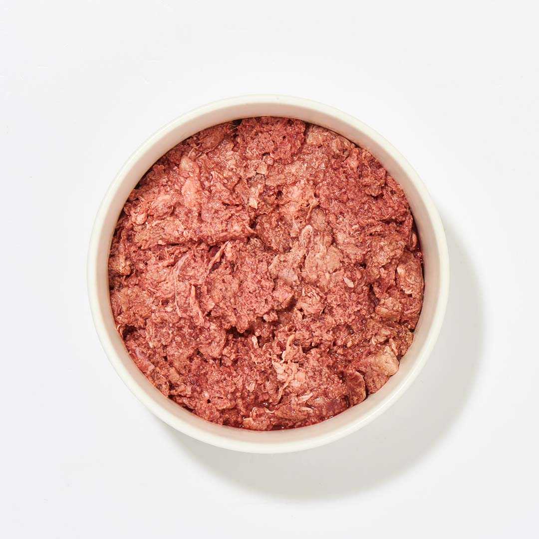 Rindermuskelfleisch Extra in weißer Schüssel, reich an Proteinen und Fettsäuren, geeignet für alle Hunderassen.