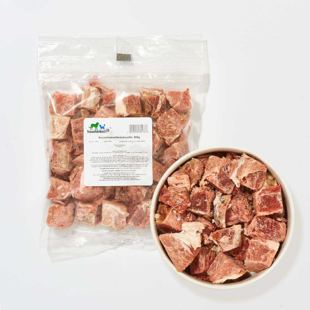 Rindermuskelfleischwürfel, 500 g Packung und Schale mit Fleischstücken vor weißem Hintergrund.