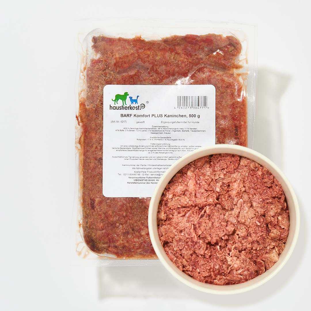 BARF Komfort PLUS Kaninchen packaged meal with visible minced rabbit blend, carrots, apples, pears, and nutritional supplements in a bowl.