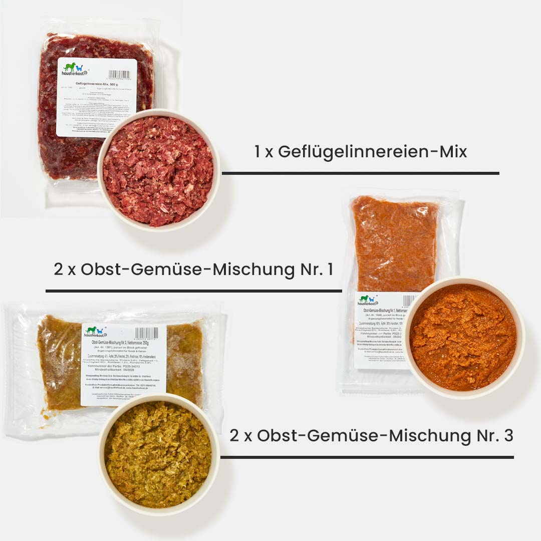 VERPACKTES Starterset für ausgewachsene Hunde mit Geflügelinnereien-Mix und Obst-Gemüse-Mischungen in Schalen und vakuumverpackten Paketen auf weißem Hintergrund