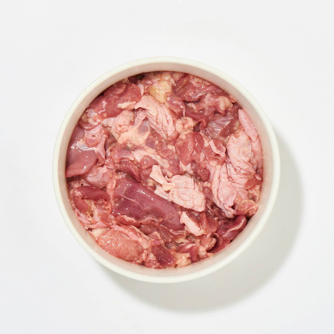Putenfleischstücke mit Haut, 500 g, tiefgekühlt in einer Schüssel.