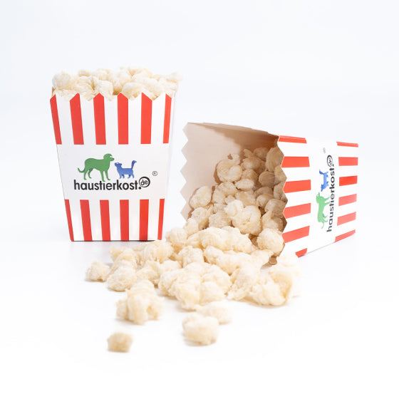 Hundepopcorn mit Leber und Kräutern, in einer gestreiften Snackbox verteilt.