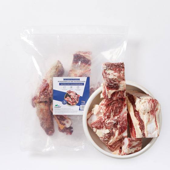 Rinderbrustbeinknochen in Schüssel neben verpacktem Produkt, reine Fleischknochen für Hunde, Marke "Feinstes aus Finnland".