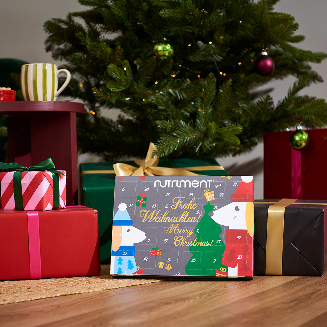 Nutriment Adventskalender für Hunde mit getreidefreien Fleisch-Snacks unter Tannenbaum und Geschenken