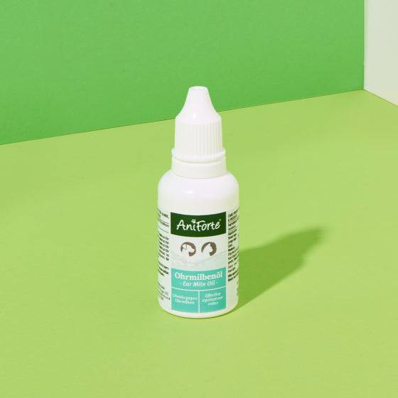 AniForte® Ohrmilbenöl 20 ml Flasche auf grünem Hintergrund für Ohrenpflege bei Haustieren.