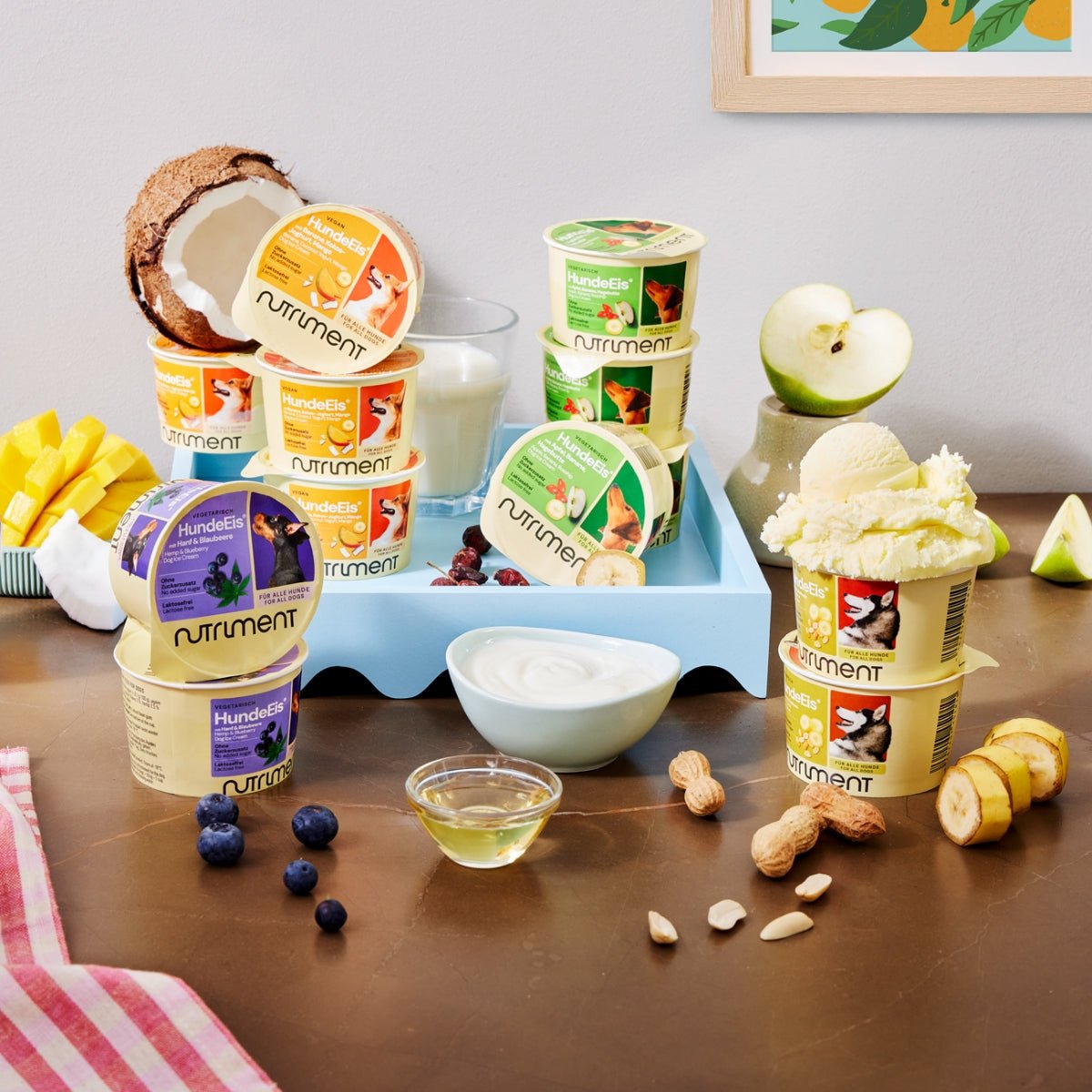 Nutriment HundeEis veganes Hundeeis mit Banane, Kokos-Joghurt und Mango in Bechern mit Früchten und Nüssen auf Holztisch